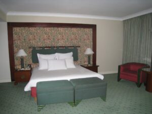 a bed with white sheets and a green couch