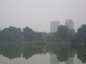a body of water with trees and buildings in the background