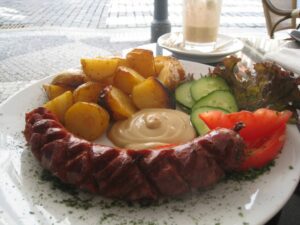 a plate of food with a sausage and vegetables