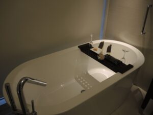 a bathtub with a tray and wine glasses