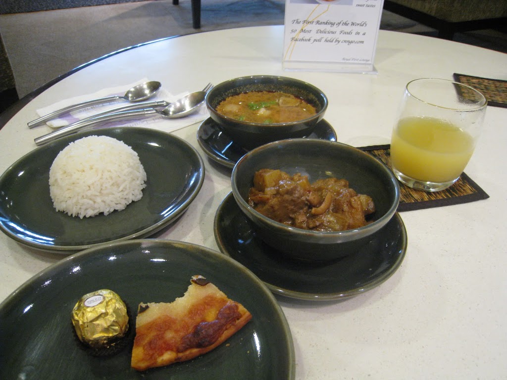 a table with plates of food and a glass of juice