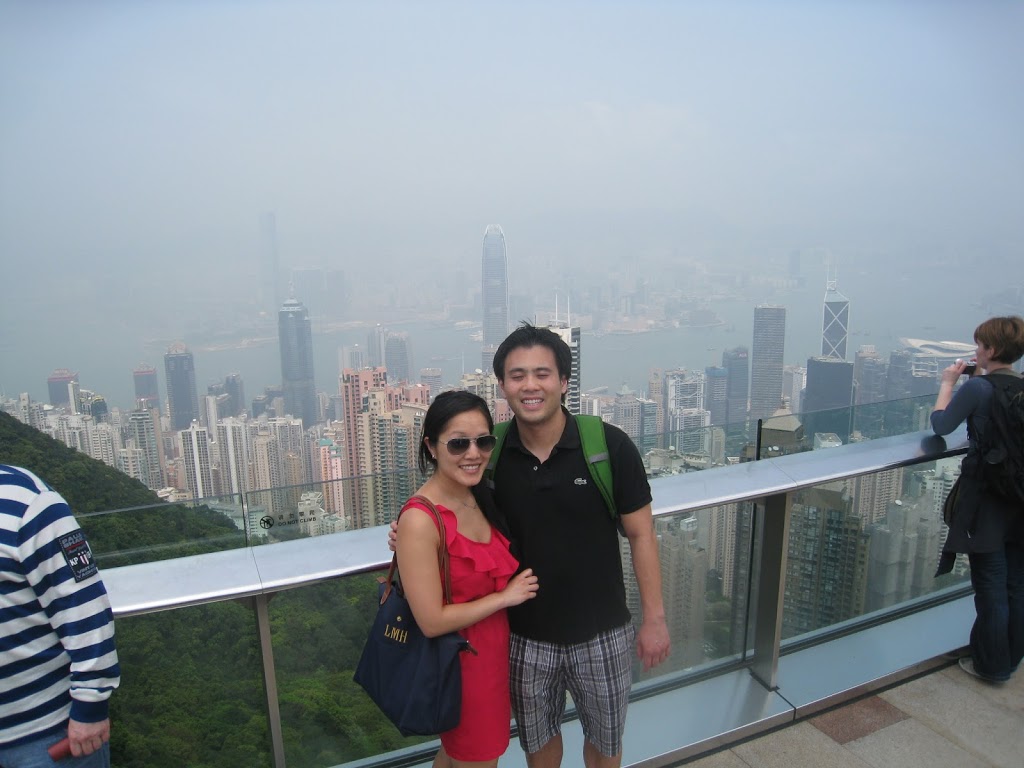 a man and woman posing for a picture with a city in the background