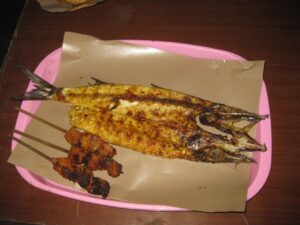 a grilled fish on a pink tray