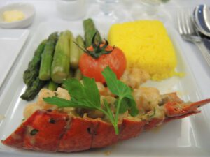 a lobster tail with vegetables and rice on a plate