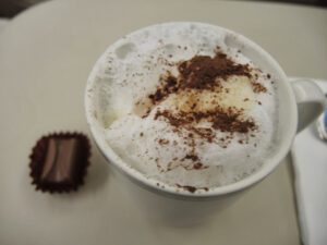 a cup of coffee with a chocolate candy