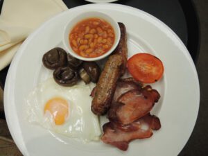 a plate of breakfast with sausage and beans