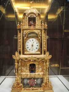 a gold clock in a glass case