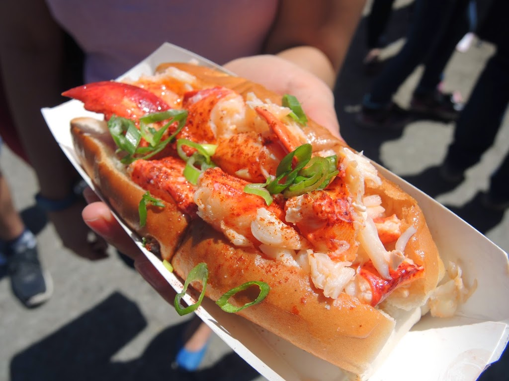 a hand holding a lobster roll