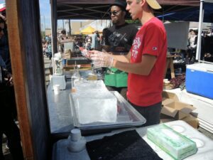 a man standing next to a tray of ice