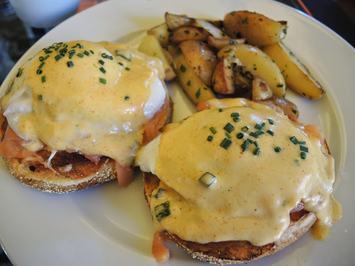 a plate of food with eggs benedict and potatoes