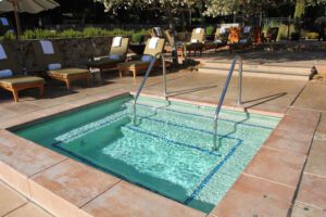 a pool with a ladder and chairs