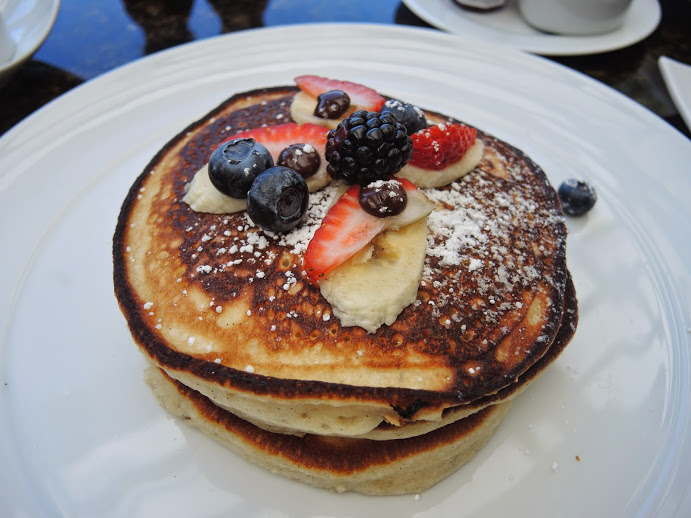 a stack of pancakes with fruit on top
