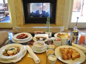 a table with plates of food and a fireplace