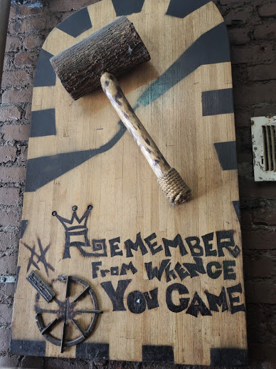 a wooden sign with a hammer on it