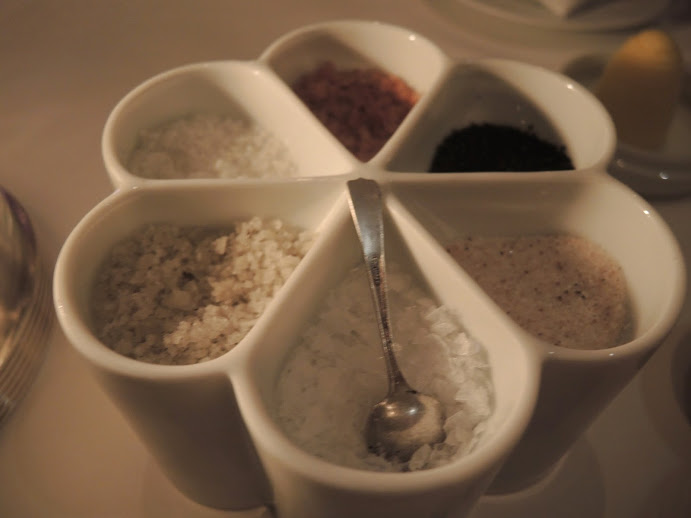 a white container with different colored salt and pepper