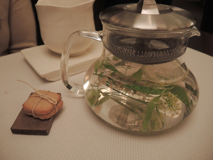 a glass teapot with water and a cookie