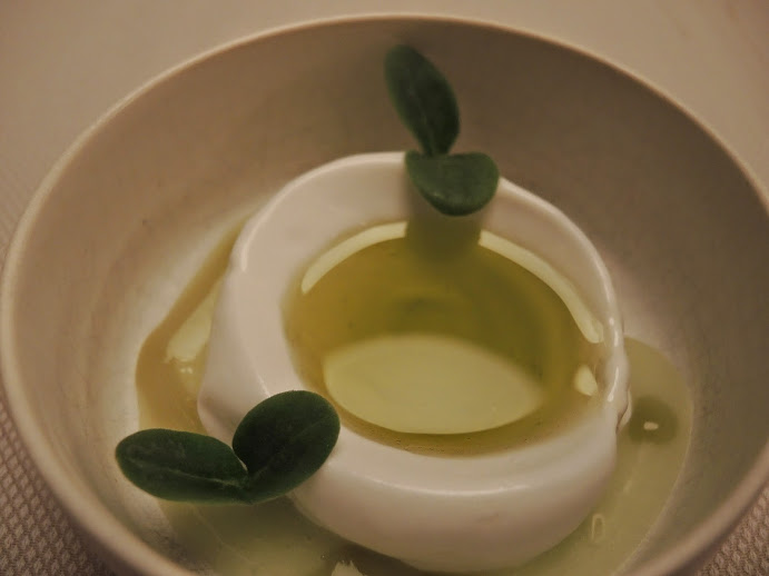 a white object with green leaves in a bowl