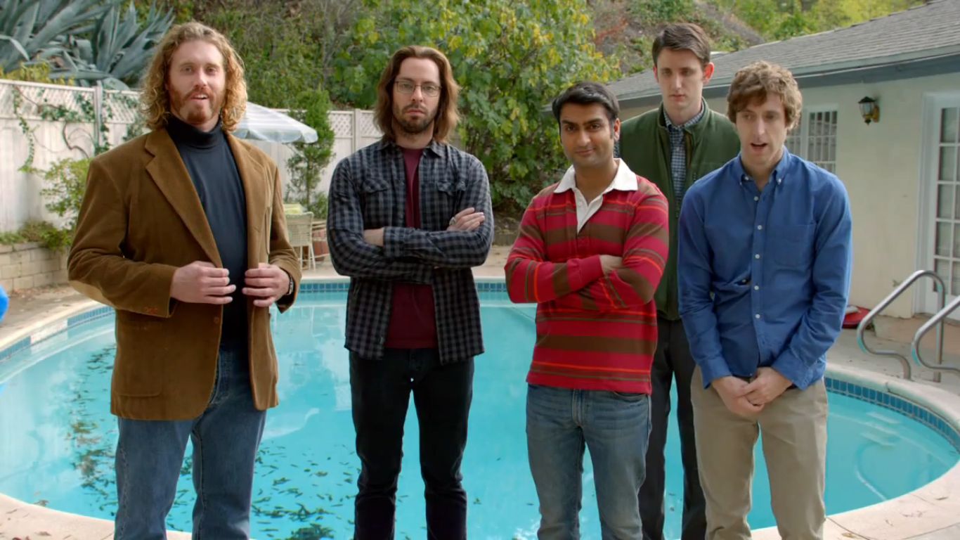 a group of men standing next to a pool