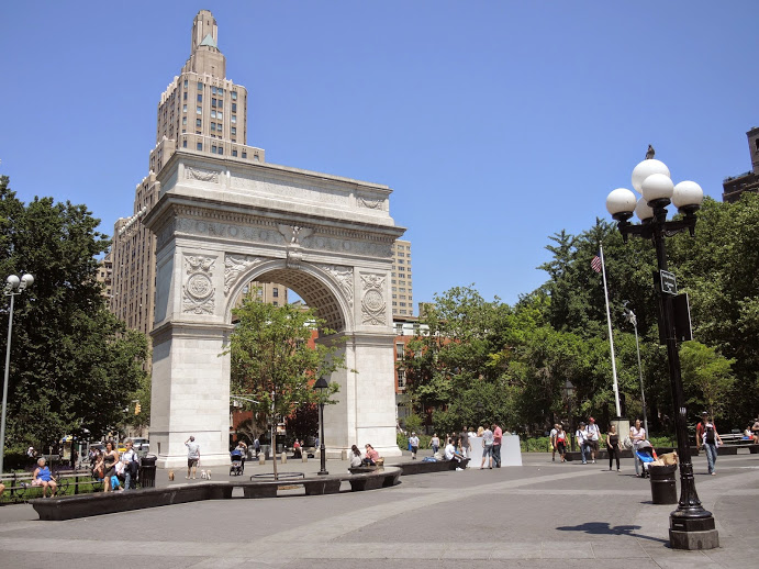 a stone archway in a park with Washington Square Park in the background