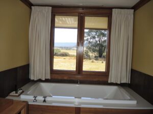 a bathtub and window with a view of a field