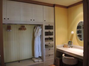 a room with a dressing table and a white robe