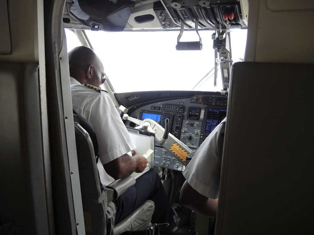 a man in a white shirt sitting in a cockpit of an airplane
