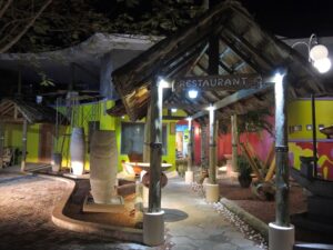 a restaurant with a thatched roof and a sign