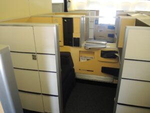 a cubicle with a desk and drawers