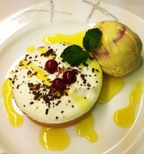 a plate of food with a scoop of ice cream and a fruit on it