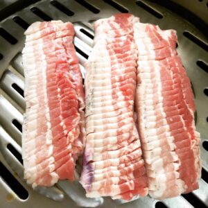 a group of raw meat on a grill
